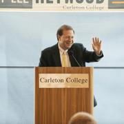 President Steven G. Poskanzer standing behind a podium waving